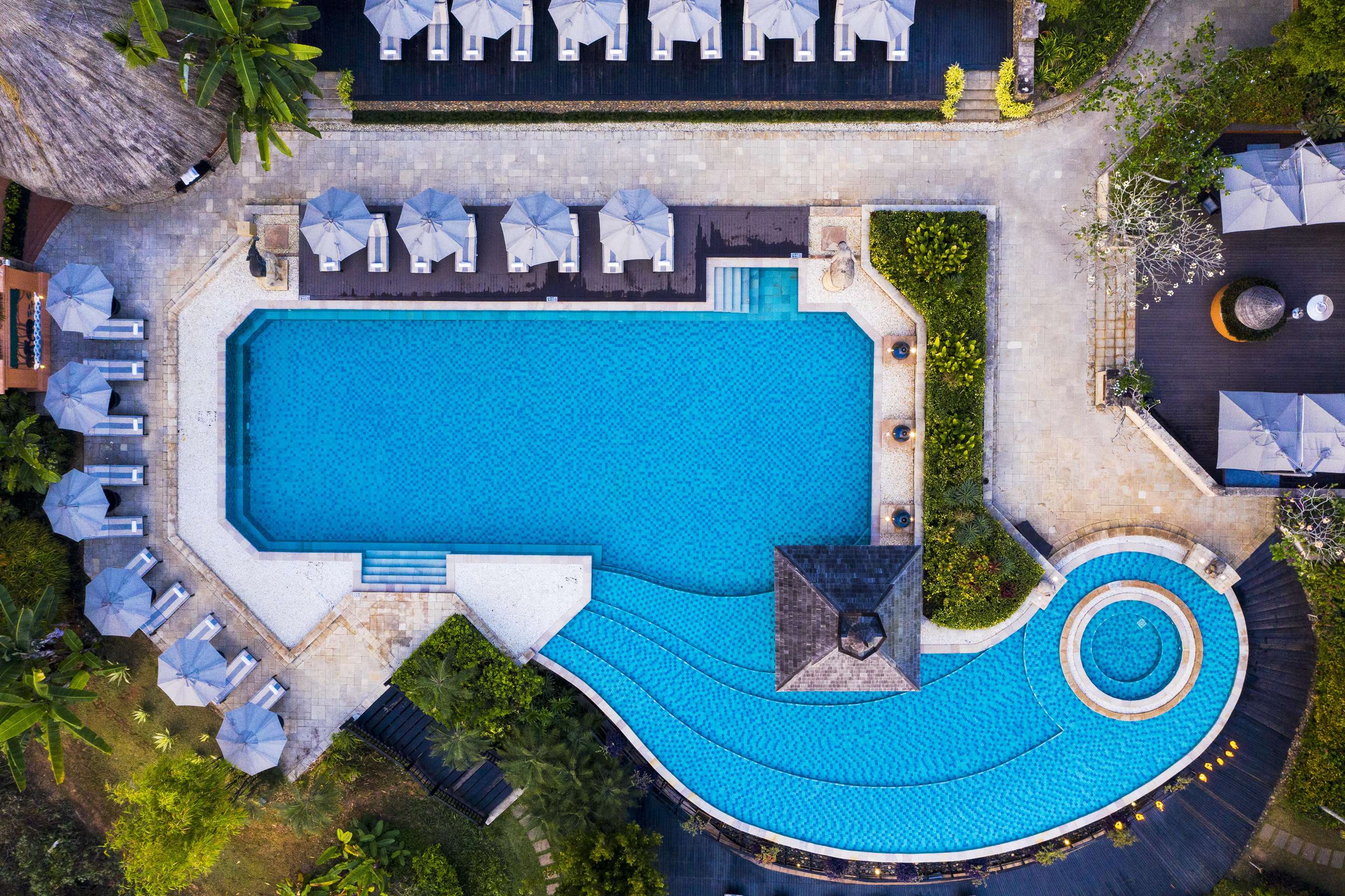 Aerial view of swimming pool with sun-loungers and umbrellas