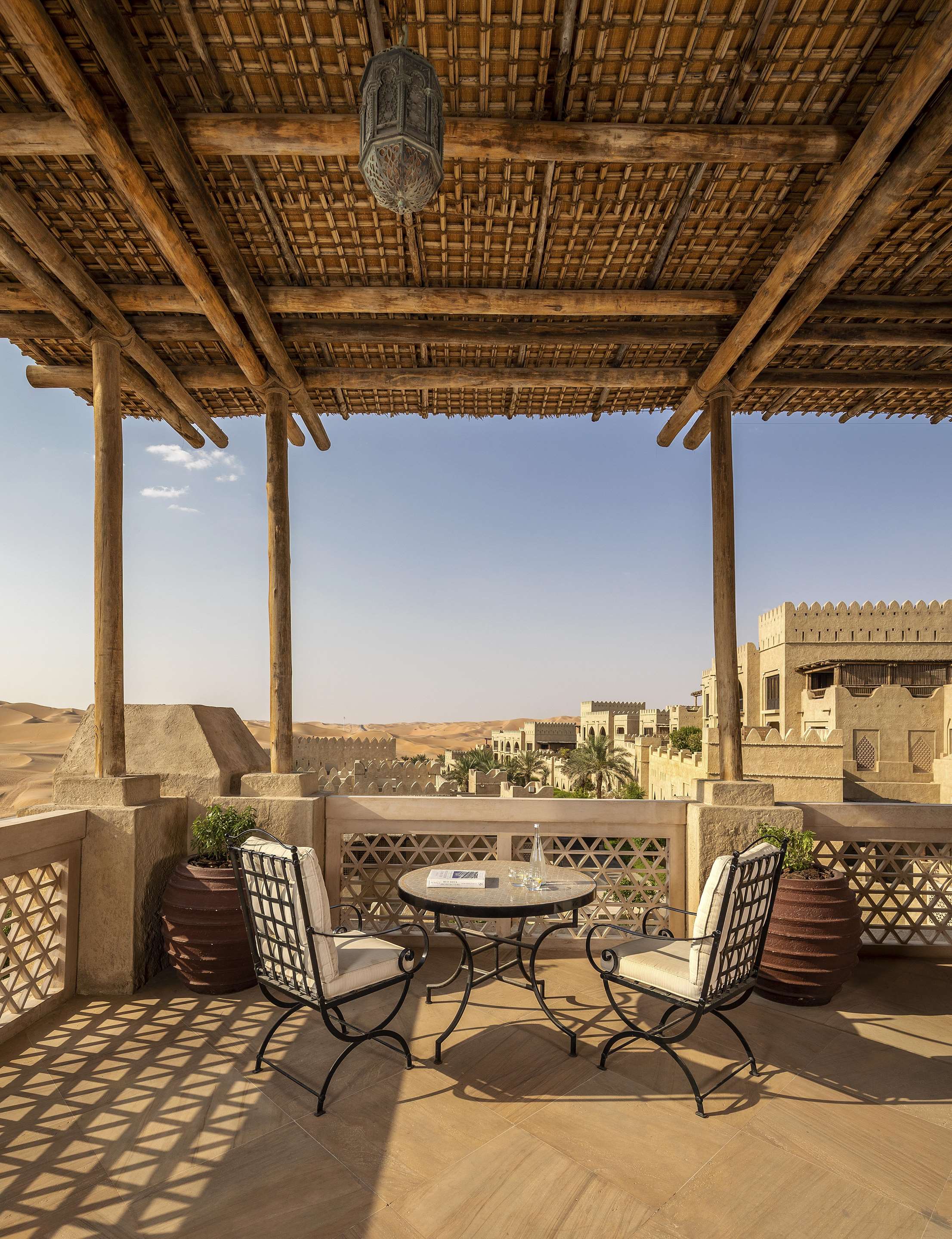 Exterior view of covered terrace with seating area and desert view