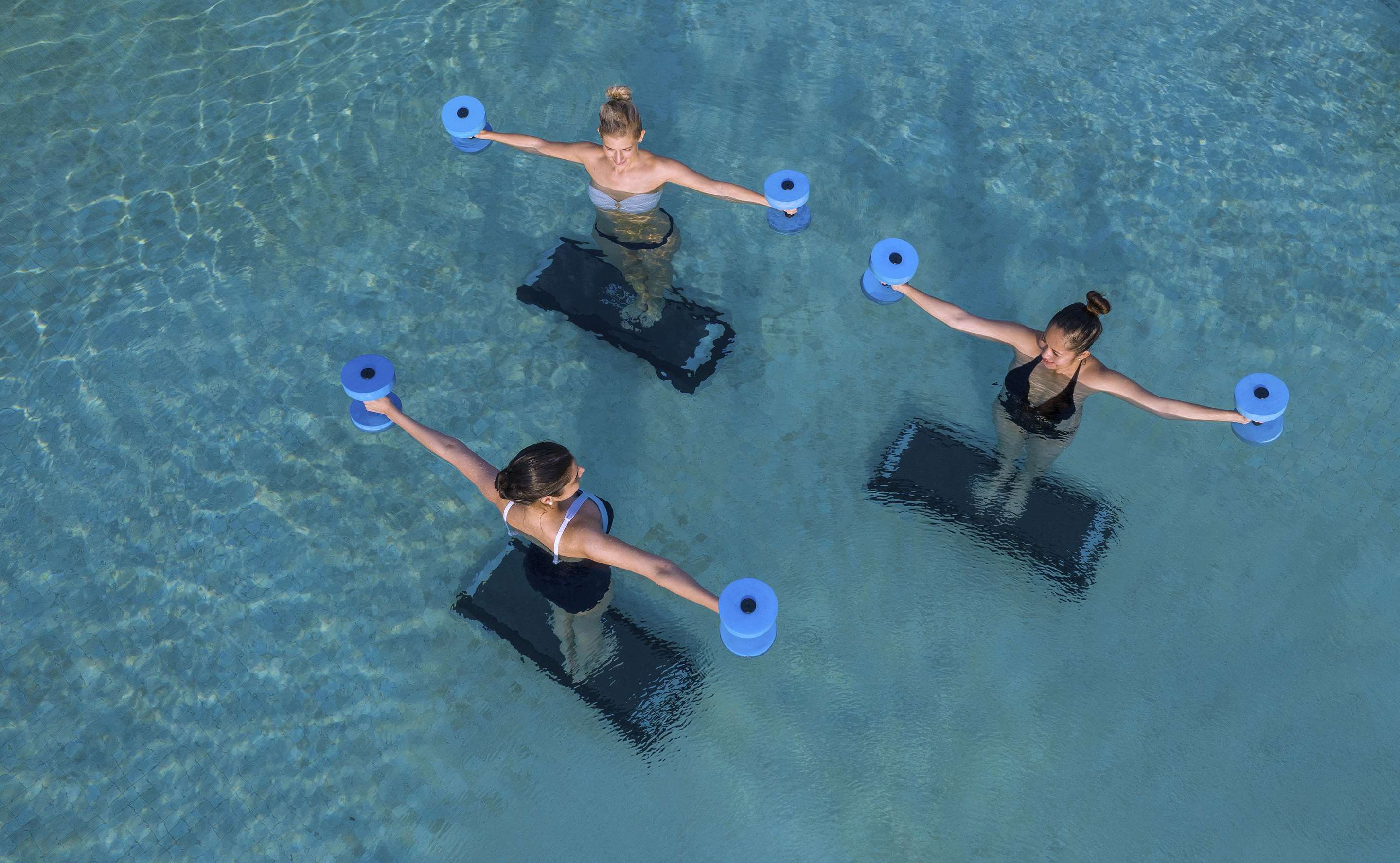 Aerial view of aqua aerobics in pool with instructor and guests